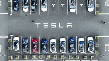 In an aerial view, Tesla cars sit parked in a lot at the Tesla factory on April 20, 2022 in Fremont, California