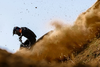 A rider on a Ducati motorcycle kicking up dirt