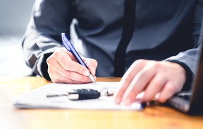 Car loan form or lease application document. Man signing paper contract to sell premium vehicle. Buyer or dealer in agency. Auto insurance or finance paperwork.
