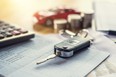 car key with money and calculator on table