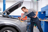 A dealership mechanic looks under the hood of a Hyundai Ioniq BEV
