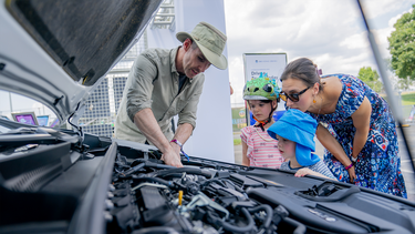 A family inspects the engine of a new Toyota Prius model during the Electrify Expo In D.C. on July 23, 2023 in Washington, D.C.