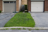 A pair of driveways and attached garages in front of two Ottawa homes in July 2013