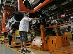 Ford employees work on the line at an assembly facility in Oakville, Canada.