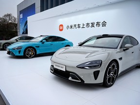 Chinese electronics company Xiaomi's first electric vehicles, the Xiaomi SU7 range, are seen on display at a launch event in Beijing on March 28, 2024
