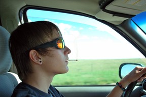 A teenage boy smoking a marijuana joint while driving