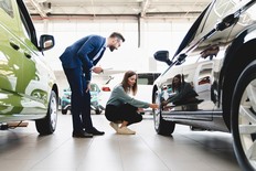 A young woman shopping for a new car at a dealership