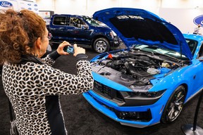 A visitor photographs the engine of a Ford Mustang at last year's Calgary International Auto and Truck Show at the BMO Centre.
