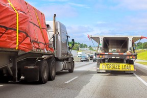Large trucks carrying oversized loads on a crowded highway