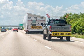 A truck carries a modular home down Interstate I-95 south to Miami, Florida, guided by an escort truck