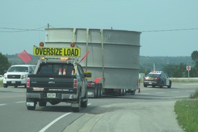 An escort truck follows a large load down an Ontario highway