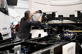 An employee works on the chassis of an electric truck at the Lion Electric plant in Saint-Jérôme, Quebec, on March 15, 2023