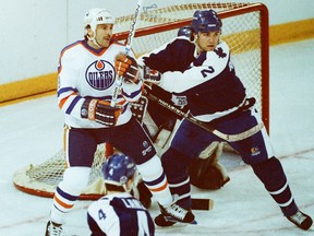 Edmonton Oilers forward Glenn Anderson, left, battles Toronto Maple Leafs defenceman Luke Richardson in front of goalie Ken Wregget as defenceman Rick Lanz skates in during NHL action at Edmonton's Northlands Coliseum on Nov. 19, 1988.