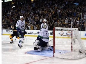 Only three people (all in foreground) appear disappointed as the first of eight pucks finds its way into Vancouver's net.