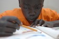 Eight-year old Sudanese-Canadian William Monga concentrates during a Saturday morning homework club. Photo by Shaughn Butts / Edmonton Journal