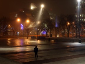 A man walks through Churchill Square on an misty evening fog in Edmonton.  Photo by John Lucas/Edmonton Journal