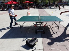 Chad Prozney and Liu Zhiwen play ping pong at a table set up in Churchill Square. Photo by John Lucas / Edmonton Journal