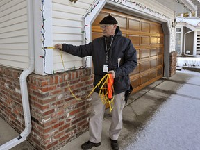 Wayne Kelly, a City of Edmonton residential home assessor, takes measurements outside a home in south Edmonton. Photo by Larry Wong/Edmonton Journal