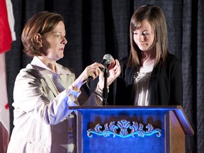 Alison Redford fixes the microphone for 13-year-old Slave Lake resident Nykaea Lebsack. Photo by Greg Southam / Edmonton Journal