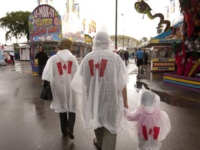 Fair-goers walk through the rain at Capital Ex on Saturday, July 28, 2012. Greg Southam/Edmonton Journal