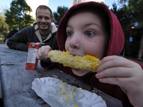 Seven-year-old Liam Dixon enjoys his corn cob as his dad Jon looks on in Beaverhills Park during the EFCL's Community Leagues Day in Edmonton on Saturday, Sept. 15, 2012. (Photo by John Lucas/Edmonton Journal)