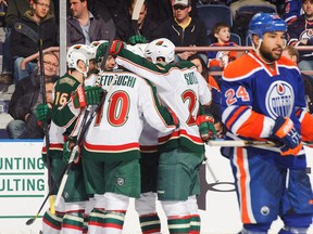 Matt Cullen #7 of the Minnesota Wild celebrates his goal with Devin Setoguchi #10, Jason Zucker #16, and Ryan Suter #20 as Edmonton Oilers defenceman Theo Peckham skates by during their NHL game on Feb. 21, 2013 in Edmonton. The Wild won 3-1. Photo by Derek Leung/Getty Images