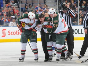 Cal Clutterbuck is helped off  the ice after a hit from Taylor Hall late in Thursday's game. (Photo: Andy Devlin/Getty Images)