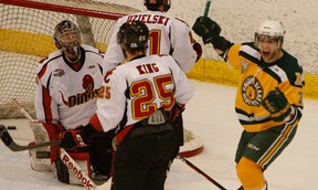 Alberta Golden Bears' Drew Nichol, right, celebrates a goal scored by teammate Ian Barteaux (not pictured) on Calgary Dinos goalie Dustin Butler during their Canada West men's hockey semifinal Game 2 at Clare Drake Arena on Feb. 23, 2013 in Edmonton. Photo by Greg Southam/Edmonton Journal