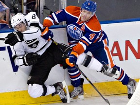 Los Angeles Kings' Drew Doughty, left, is checked by Edmonton Oilers' Taylor Hall during third period NHL hockey action in Edmonton, Alta., on Tuesday February 19, 2013. THE CANADIAN PRESS/Jason Franson.