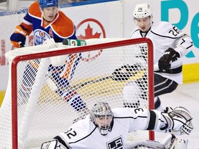 Los Angeles Kings goalie Jonathan Quick, 32, makes the save as teammate Slava Voynov, 26, Edmonton Oilers' Taylor Hall, 4, look for the rebound during first period NHL hockey action in Edmonton, Alta., on Tuesday February 19, 2013. THE CANADIAN PRESS/Jason Franson.