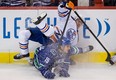 Edmonton Oilers' Eric Belanger, top, and Vancouver Canucks' Aaron Volpatti collide during the second period of an NHL hockey game in Vancouver, B.C., on Sunday January 20, 2013. THE CANADIAN PRESS/Darryl Dyck