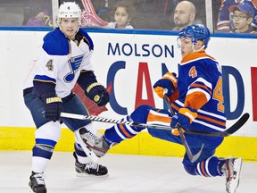 St. Louis Blues' Kris Russell, 4, checks Edmonton Oilers Taylor Hall, right, during first period NHL hockey action in Edmonton, Alta., on Saturday March 23, 2013. THE CANADIAN PRESS/Jason Franson.