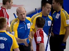 Alberta skip Kevin Martin, centre, shakes hands with Newfoundland and Labrador skip Brad Gushue following the morning draw at the Tim Hortons Brier in Edmonton on Friday, March 8, 2013. Alberta won the draw 6-5 in the 10th end. Photo by Jonathan Hayward, The Canadian Press