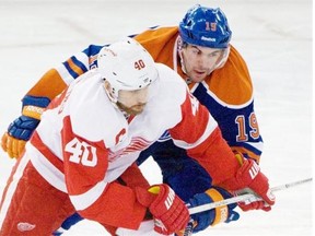 Justin Schultz of the Edmonton Oilers hangs onto Henrik Zetterberg of the Detroit Red Wings at Rexall Place in Edmonton on Friday, March 15, 2013.
Photograph by: Shaughn Butts