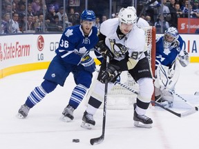 Pittsburgh Penguins' Sidney Crosby (centre) brings the puck around the goal as Carl Gunnarson (left) and goaltender James Reimer look on during third period NHL hockey action in Toronto on Saturday, March 9, 2013. Photo by Chris Young, The Canadian Press