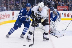 Pittsburgh Penguins' Sidney Crosby (centre) brings the puck around the goal as Carl Gunnarson (left) and goaltender James Reimer look on during third period NHL hockey action in Toronto on Saturday, March 9, 2013. Photo by Chris Young, The Canadian Press