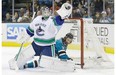 Vancouver Canucks goaltender Cory Schneider catches the puck in front of San Jose Sharks' right-winger Adam Burish during Monday's National Hockey League game in San Jose, Calif.
Photo by Jeff Chiu, The Associated Press