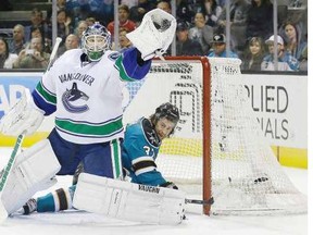 Vancouver Canucks goaltender Cory Schneider catches the puck in front of San Jose Sharks' right-winger Adam Burish during Monday's National Hockey League game in San Jose, Calif.
Photo by Jeff Chiu, The Associated Press