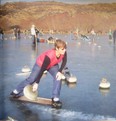 A curler throws a rock from a crampit during a New Zealand bonspiel that's been held on an outdoor lake since 1879.