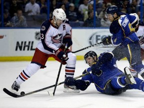 St. Louis Blues forward David Backes, centre, manages to reach the puck and score as he falls to the ice while teammate Jaden Schwartz, right, and Columbus Blue Jackets defenceman Adrian Aucoin, left, look on during the 3-1 Blues home win on Friday, April 5, 2013. Photo by Jeff Roberson, Associated Press