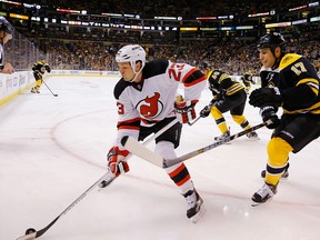 New Jersey Devils' David Clarkson takes the puck into the corner with Milan Lucic hot on his heels. (Photo: Jared Wickerham/Getty Images)