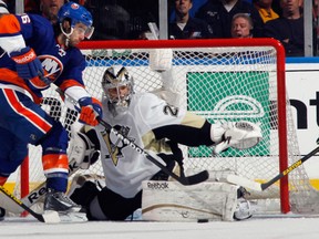 New York Islanders forward Matt Moulson, left, tries to get the puck on Pittsburgh Penguins goalie Marc-Andre Fleury during Game 4 of their NHL playoff series May 7, 2013, in Uniondale, N.Y. Photo by Bruce Bennett, Getty Images