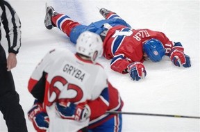 Montreal Canadiens' Lars Eller lies injured on the ice following a hit by Ottawa Senators' Eric Gryba (62) during NHL playoff action in Montreal, Thursday, May 2, 2013. Montreal Canadiens coach Michel Therrien accused Ottawa Senators counterpart Paul MacLean of "disrespect" on Friday for his comments about a hit that put Habs centre Lars Eller in hospital. THE CANADIAN PRESS/Graham Hughes