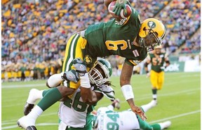 Edmonton Eskimos quarterback Jacory Harris dives into the end zone for a touchdown while being tackled by Saskatchewan Roughriders linebacker Anthony Heygood during third quarter pre-season Canadian Football League game action in Edmonton on June 14, 2013.
Photograph by: Larry Wong, EDMONTON JOURNAL