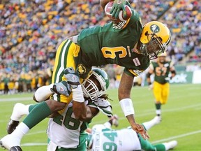 Edmonton Eskimos quarterback Jacory Harris dives into the end zone for a touchdown while being tackled by Saskatchewan Roughriders linebacker Anthony Heygood during third quarter pre-season Canadian Football League game action in Edmonton on June 14, 2013.
Photograph by: Larry Wong, EDMONTON JOURNAL