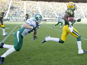 Edmonton Eskimos' Marcell Young (23) runs for a touchdown as Saskatchewan Roughriders' Rob Bagg (6) chases during first half pre-season action in Edmonton, Alta., on Friday June 14, 2013. THE CANADIAN PRESS/Jason Franson.