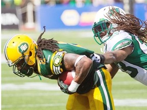 Edmonton Eskimos receiver Fred Stamps, left, tries to break the grasp of Saskatchewan Roughriders defensive back Dwight Anderson on June 29, 2013. Stamps has been limited in practice heading into the July 7 road game against the Hamilton Tiger-Cats.
