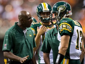 Edmonton Eskimos' head coach Kavis Reed, left, shouts at quarterback Mike Reilly after he came off the field after failing to gain the first down against the B.C. Lions during the second half of a CFL football game in Vancouver, B.C., on Saturday July 20, 2013. THE CANADIAN PRESS/Darryl Dyck