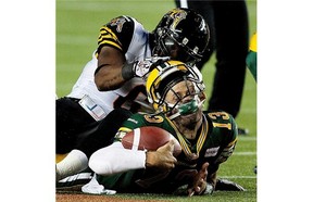 Edmonton Eskimos’ Mike Reilly #13 has his helmet pulled up by Hamilton Tiger-Cats’ Nate Bussey #6 during second-half action on August 2, 2013, at Commonwealth Stadium in Edmonton.
Photograph by: Greg Southam, Edmonton Journal