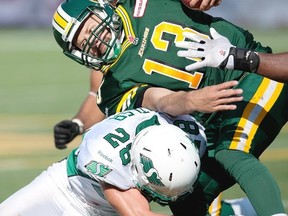 Edmonton Eskimos quarterback, Mike Reilly scrambles against the Saskatchewan Roughriders during second half CFL football game action in Edmonton, Alta., on Saturday, August 24, 2013. THE CANADIAN PRESS/John Ulan